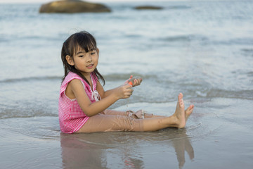 Asian cute little girl Playing on the beach Sea sky background