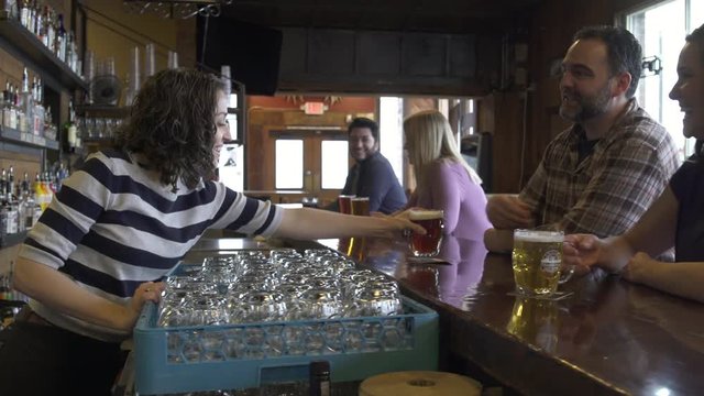 Waitress serving beer and peanuts to a couple
