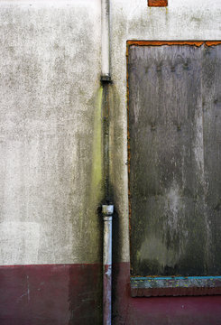 Broken drainpipe on a dirty wall