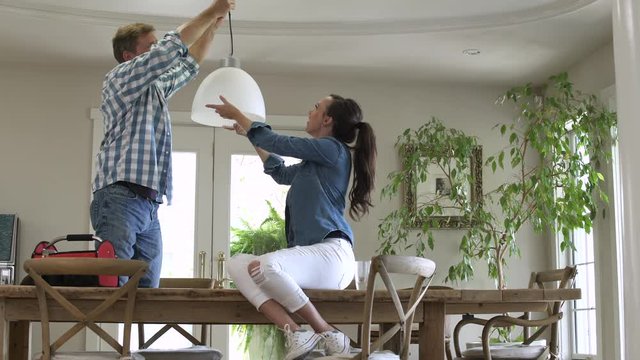 Mid adult couple installing a lamp