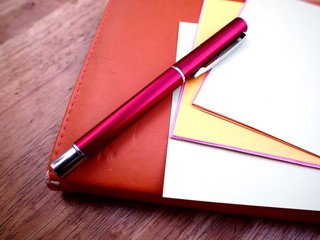 Pen, notebook and colored papers