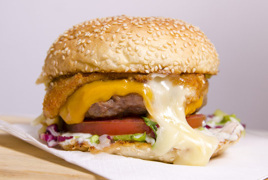 Closeup shot of tasty burger with fried cheese dripping 