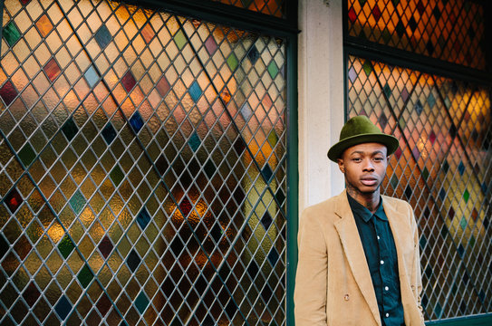 Stylish young black man with tattoos and hat