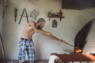 Caucasian man mending the fire in traditional stove