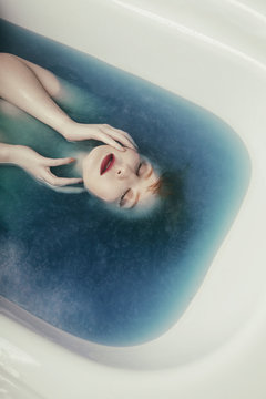 Woman lying in blue water
