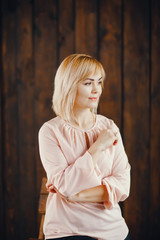 blonde girl standing by a wall