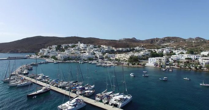 flight over the town of Adamas with beautiful white houses and churches, Milos island Cyclades, Greece