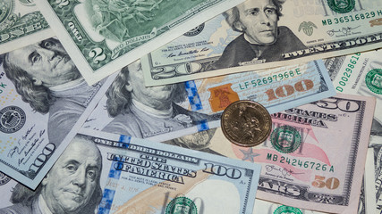 background from the heap of American dollars and a one-dollar coin, top view