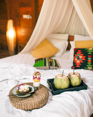 Breakfast on the bed with a canopy. Healthy food. Coconut, gluten-free pancakes and coconut granola