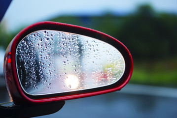 Rainy day on the road, Raindrops on car mirror with side wing mirror