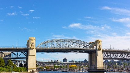 Fototapeta premium Burrard Bridge in the morning in Vancouver, British Columbia, Canada. Steel truss bridge over False Creek with imposing concrete towers.