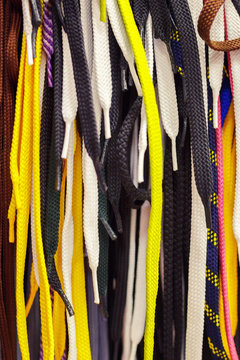 Colored Bright Shoelaces Hang In The Store. Background Of Ropes.