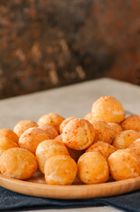 Small cottage cheese doughnuts (castgnole) served on a wooden plate. Festive dessert.