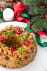 Colorful Christmas fruitcake topped with almonds and glace cherries