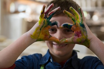 Boy gesturing with painted hands - Powered by Adobe
