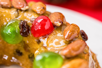 Fototapeta na wymiar Christmas fruitcake topped with almonds and glace cherries
