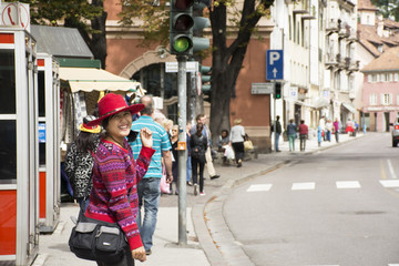 Travelers asian thai women walking on footpath beside road go to handmade street market, Italy