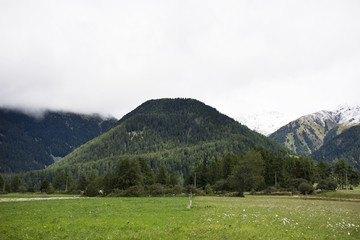 View landscape of mountain and grass field beside road in Schnals city in Bolzano, Austria