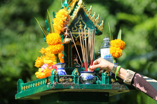 Asian people with incense pay respect to shrine or spirit worship