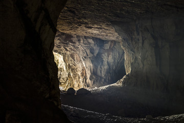 The rays of light make their way through the entrance to the old dark cave.
