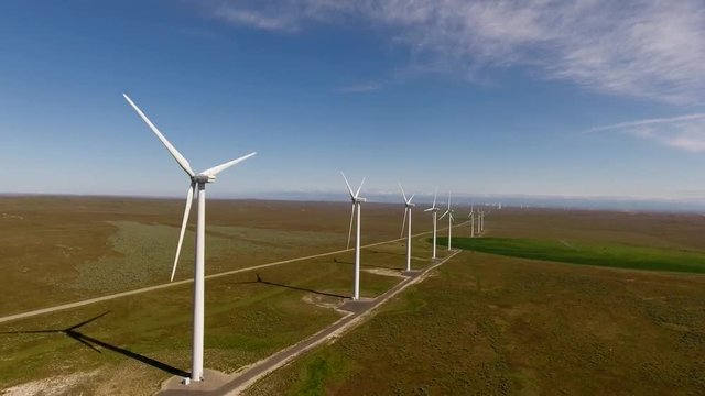 Aerial view of some windmills overlooking some farms.