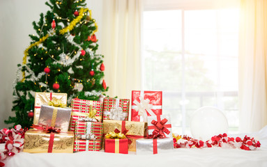 Gift boxes with Christmas tree at the background for surprise Children in New year or Xmas party festival. Christmas party event and Happy new year theme. Decorated property in worm home.