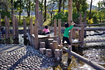 冬の公園の遊具で遊ぶ子供たち