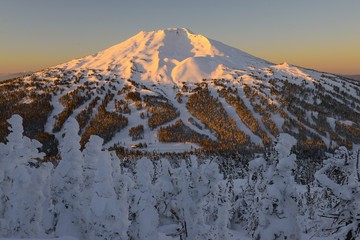 The snow covered Cascade Mountains and frozen trees at sunrise in winter