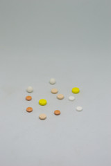 Medical pills of different colors on a white background