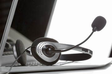 call center support concept. headset on keyboard computer laptop