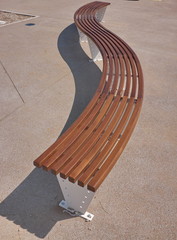 Banc de bois sinueux sur une promenade