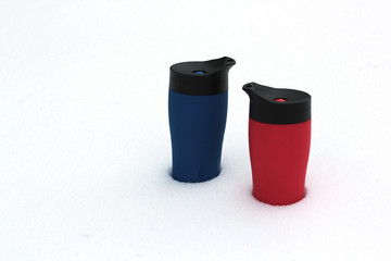 colorful thermoses in the snow red and blue