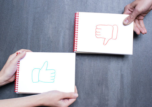Man`s and woman`s hands showing like and dislike signs.