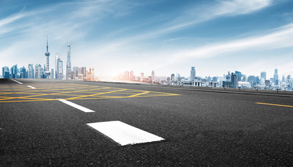 empty asphalt road with cityscape of shanghai in blue sky