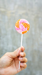 Men holding a lollipop on a gray background.