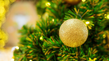 Golden ball hanging on a Christmas tree.