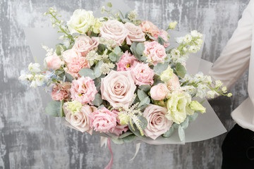 beautiful luxury bouquet of mixed flowers in woman hand. the work of the florist at a flower shop