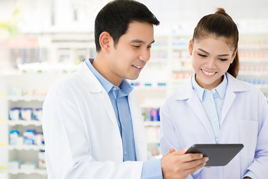 Asian Pharmacist Team Working In Chemist Shop Or Pharmacy