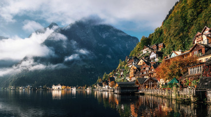 Scenic view of famous Hallstatt lakeside town reflecting in Hallstattersee lake in the Austrian Alps in morning light in autumn with clouds, Salzkammergut region, Austria