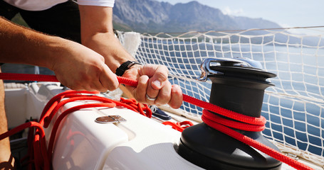 Young strong woman sailing the boat