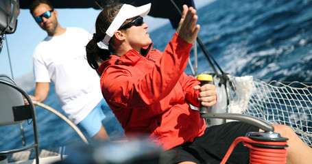 Young strong woman sailing the boat