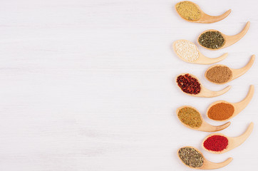 Spices collection on white soft wood board with copy space, top view.
