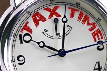 tax time concept clock closeup isolated on white background with red words