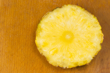 Ripe sliced pineapple on wooden table, top view