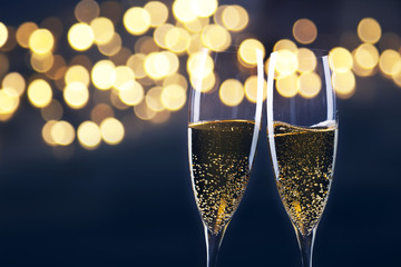 toasting with champagne glasses against holiday lights and new year fireworks