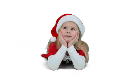 Kind mit Nikolausmütze träumt vor sich hin