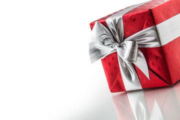 Christmas valentine or birthday red gift box with silver ribbon isolated on white
