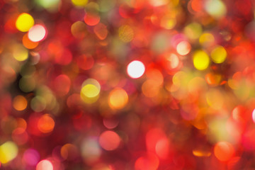 Closeup top view of defocused Christmas decoration of red, yellow, golden colorful circles. Horizontal color photography.