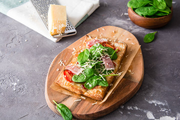 Homemade puff pastry pie with spinach, ham and cheese.