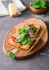 Homemade puff pastry pie with spinach, ham and cheese.